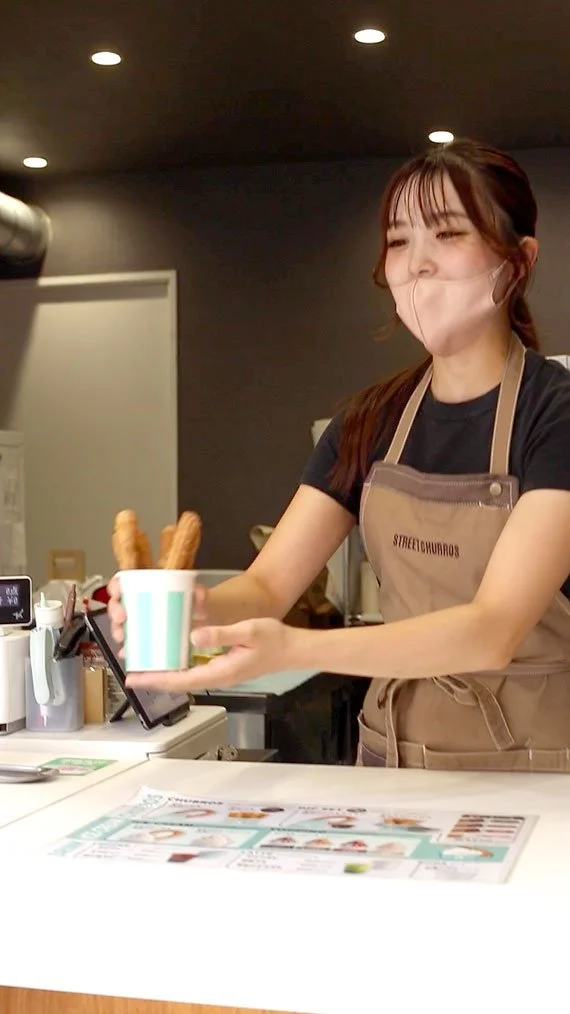 木のカウンターと調理スペースが見えるチュロス店の店内